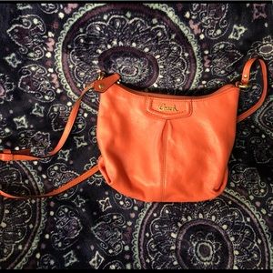 Peach small Coach crossbody bag.